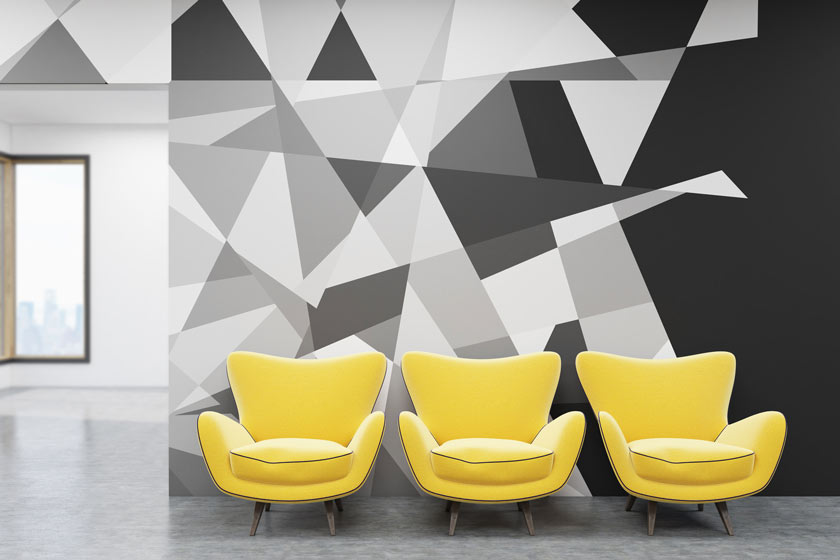 Zdjęcie żółtych foteli na tle szarej ściany we wzory